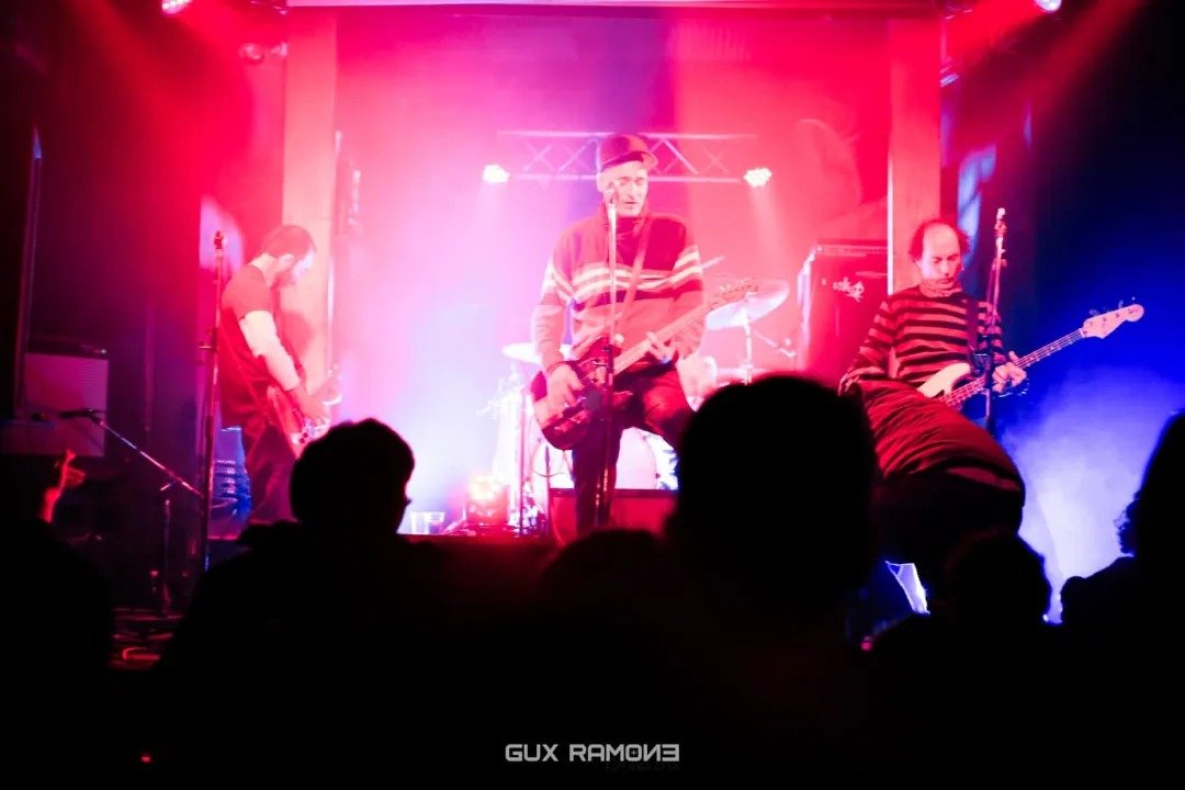 Responsables No Inscriptos tocando en vivo bajo luces rojas